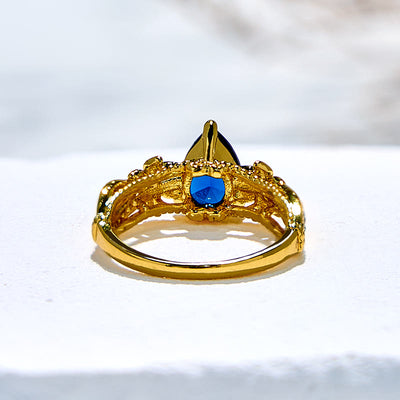 Olivenorma Ring mit blauem Topas und floralen Zirkon-Akzenten